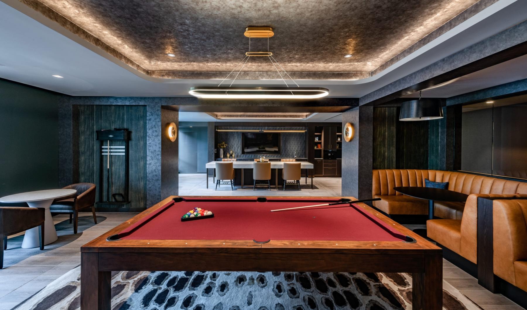a room with a pool table and chairs